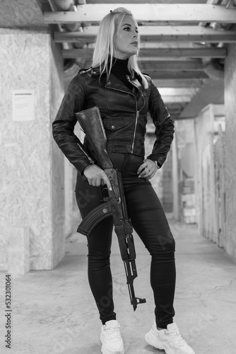 A girl with an ak 47 in a shooting range, black and white photo.