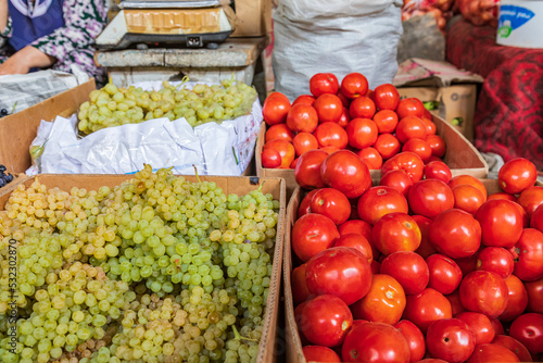 Panjakent, Sughd Province, Tajikistan. Green grapes and tomatoes for sale at the market in Panjakent. photo
