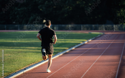 Veteran Working Out and Stretching at Track in Morning Light