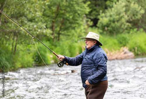 An older man tries his luck at fly fishing for salmon. Russian River. Cooper Landing, Alaska.