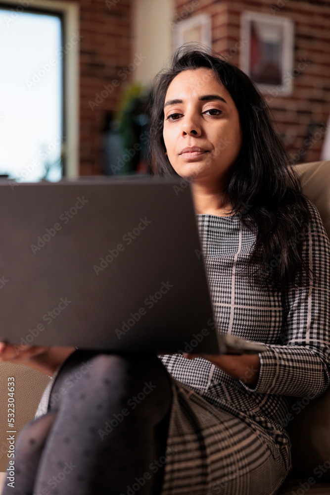 Young adult browsing internet on laptop, working on business report from home. Using online network to do research information for freelance work, attending online school webinar. Young adult browsing internet on laptop, working on business report from home. Using online network to do research information for freelance work, attending online school webinar.