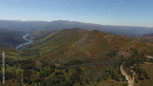 Flying Over Pine Trees in Green Mountain Valley to the River. Stuning Nature Landscape from Portugal. Blue Sky at Summer Day. photo