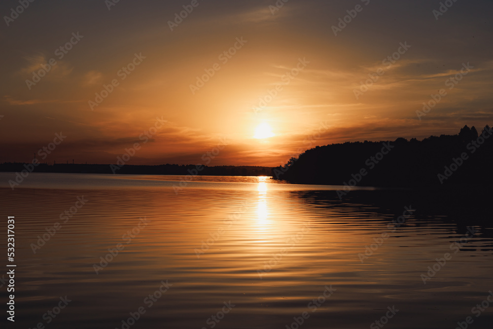 Beautiful sunset of a warm summer evening on the shore of a quiet lake Beautiful sunset of a warm summer evening on the shore of a quiet lake