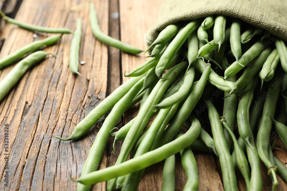 Fresh green beans in bag on wooden table, closeup Fresh green beans in bag on wooden table, closeup