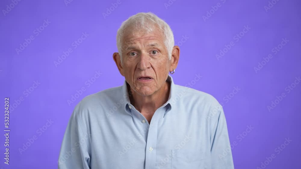 Pensive then excited surprised elderly gray-haired man 70s wears blue shirt hold say wow yes do winner gesture isolated on plain light purple background studio portrait Pensive then excited surprised elderly gray-haired man 70s wears blue shirt hold say wow yes do winner gesture isolated on plain light purple background studio portrait
