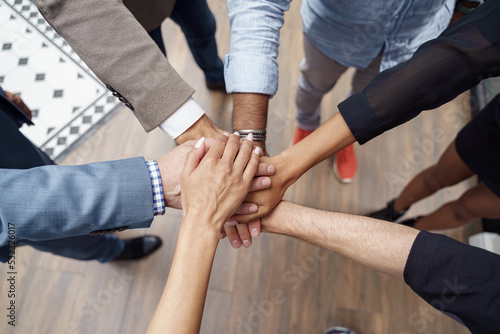 Top view of group multi ethnic coworkers stacked hands together as concept of corporate unity