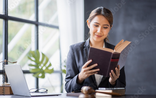 Attractive lawyer in office Business woman and lawyers discussing contract papers with brass scale on wooden desk in workplace. Law, legal services, advice, Justice and real estate concept.
