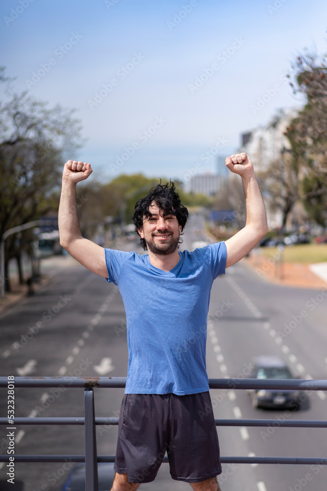 Successful man raising arms after running. Fitness male athlete with arms up celebrating success and goals after sport exercising . Successful man raising arms after running. Fitness male athlete with arms up celebrating success and goals after sport exercising .