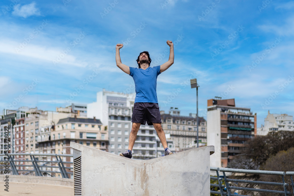 Successful man raising arms after running. Fitness male athlete with arms up celebrating success and goals after sport exercising . Successful man raising arms after running. Fitness male athlete with arms up celebrating success and goals after sport exercising .