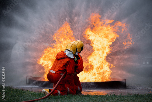 Firefighters safety using twirl water fog type fire extinguisher to fighting with fire from oil and gas to control fire not to spread out Firefighter stop this accident and safety concept.