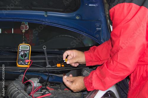 Hands of an auto electrician changing fuses on a broken down car. Mechanical and electronic works on automobiles 