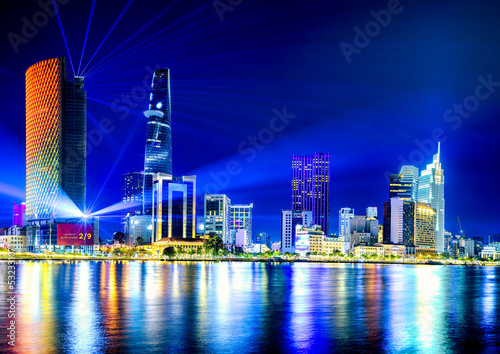 View of Hochiminh city at night from the bank of Saigon river, Vietnam.