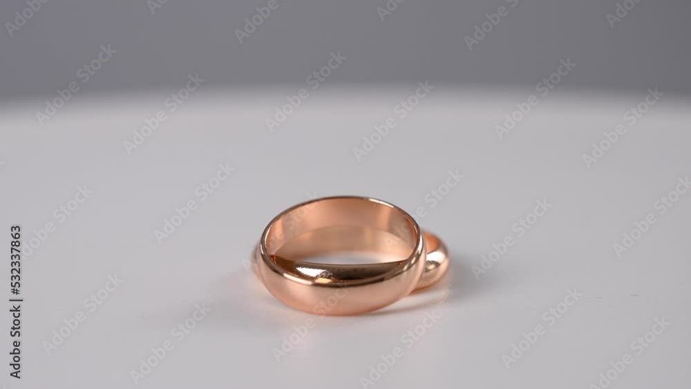 Two wedding rings spin on a white background. Two wedding rings spin on a white background.