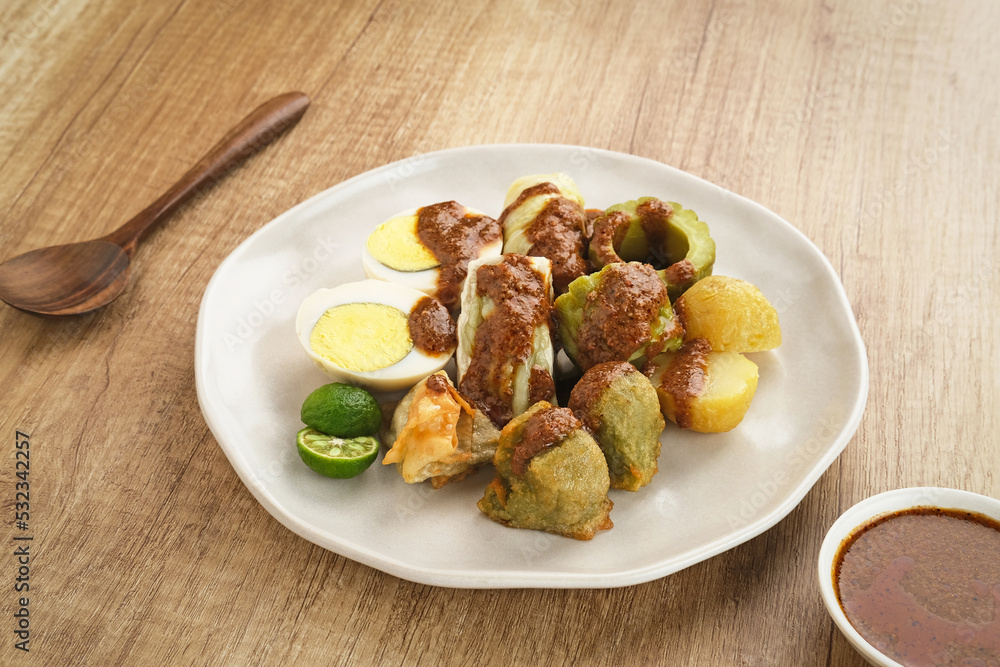 Siomay Bandung (Shumay) or steamed dumplings with boiled egg, tofu, potatoes and cabbage roll. Indonesian traditional street food with peanut sauce and soy sauce, and green lime.
Siomay Bandung (Shumay) or steamed dumplings with boiled egg, tofu, potatoes and cabbage roll. Indonesian traditional street food with peanut sauce and soy sauce, and green lime.