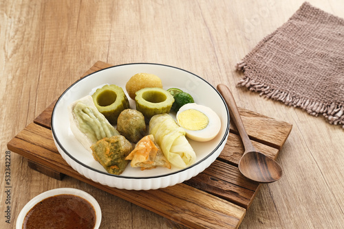 Siomay Bandung (Shumay) or steamed dumplings with boiled egg, tofu, potatoes and cabbage roll. Indonesian traditional street food with peanut sauce and soy sauce, and green lime. 
