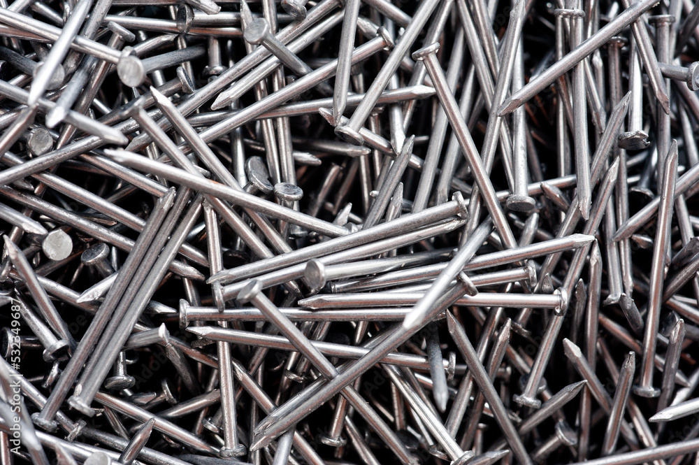 Small thin metal nails, hardware, lying in a round container. Small thin metal nails, hardware, lying in a round container.