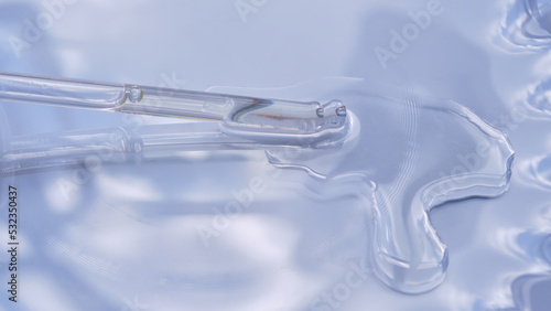Dropper with serum or cosmetic oil on a blue background.
