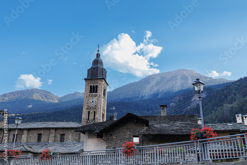 Photos View of the Bell Tower, some Houses and the Panorama with the Mountains Behind i