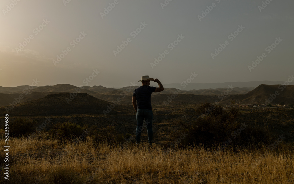 Silhouette of adult man standing on desert during sunset. Almeria, Spain