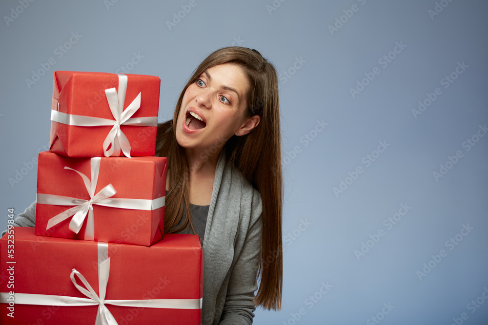 Happy woman holding stack of presents looking away. Isolated female portrait. Girl celebrate Christmas or some thing more. Happy woman holding stack of presents looking away. Isolated female portrait. Girl celebrate Christmas or some thing more.