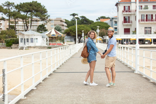 happy casual couple walking on a pier