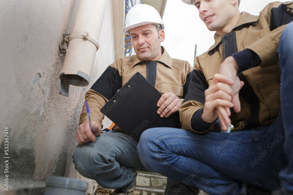 construction workers checking pipes outdoors construction workers checking pipes outdoors