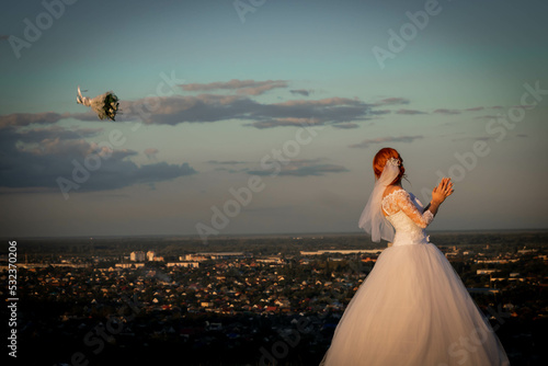 the bride throws a bouquet against the background of the city