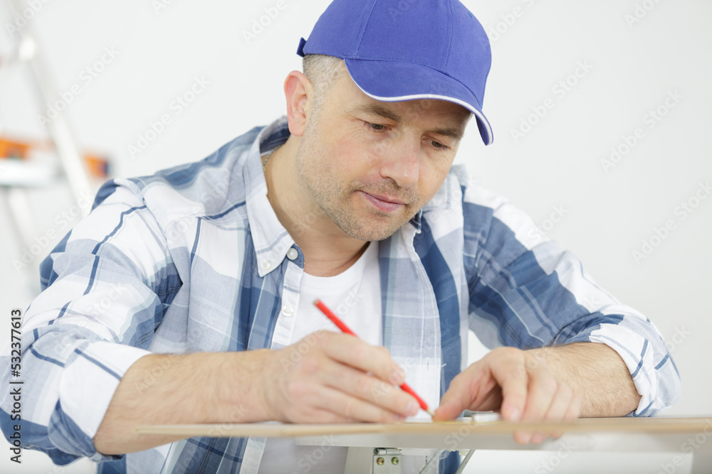 handsome cabinetmaker at the tabletop with pencil drawing handsome cabinetmaker at the tabletop with pencil drawing