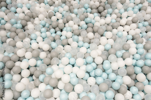 Pastel color white, grey, blue plastic balls background for baby activity. Kid's playing room interior. Copyspace