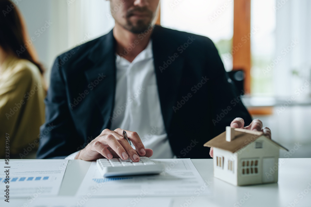 Bank staff at the Mortgage Department are working on paperwork and using a loan interest rate calculator for clients to assess their investment potential Bank staff at the Mortgage Department are working on paperwork and using a loan interest rate calculator for clients to assess their investment potential