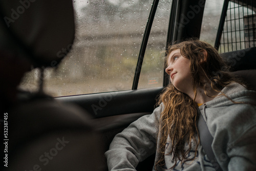 bored girl in car during long rainy trip photo