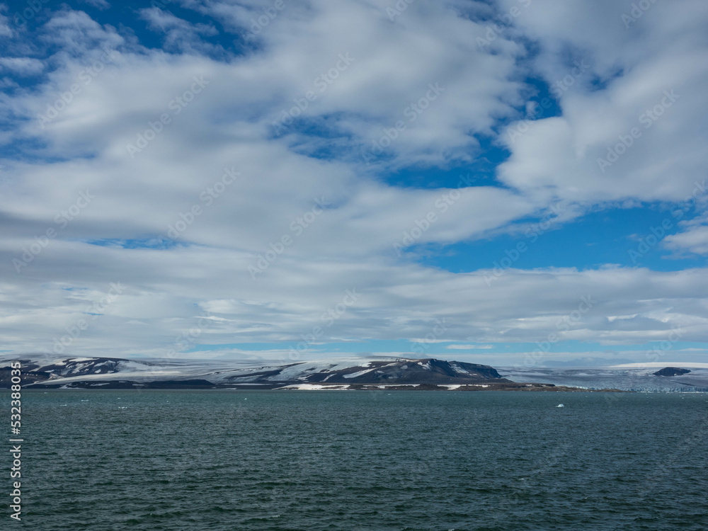 Spectacular panorama view of Wilhelmoya island with mountain range and blue sky. Torellneset, Nordaustlandet  
Spitsbergen, Norway. Tourism and vacations concept.