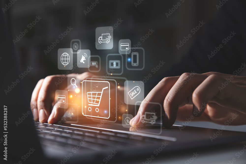 Young man using laptop with shopping cart icon,  Online shopping and e-commerce concept. - obrazy, fototapety, plakaty 
