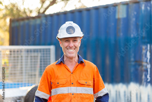 Portrait of happy smiling handyman tradie with protective headwear and high vis workwear