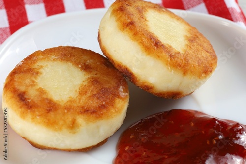 Canvastavla curd fritters in a plate with raspberry jam.