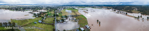 River with broken banks during flood with floodwater covering farmland