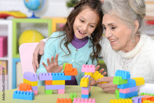 Portrait of cute girl and grandmother playing