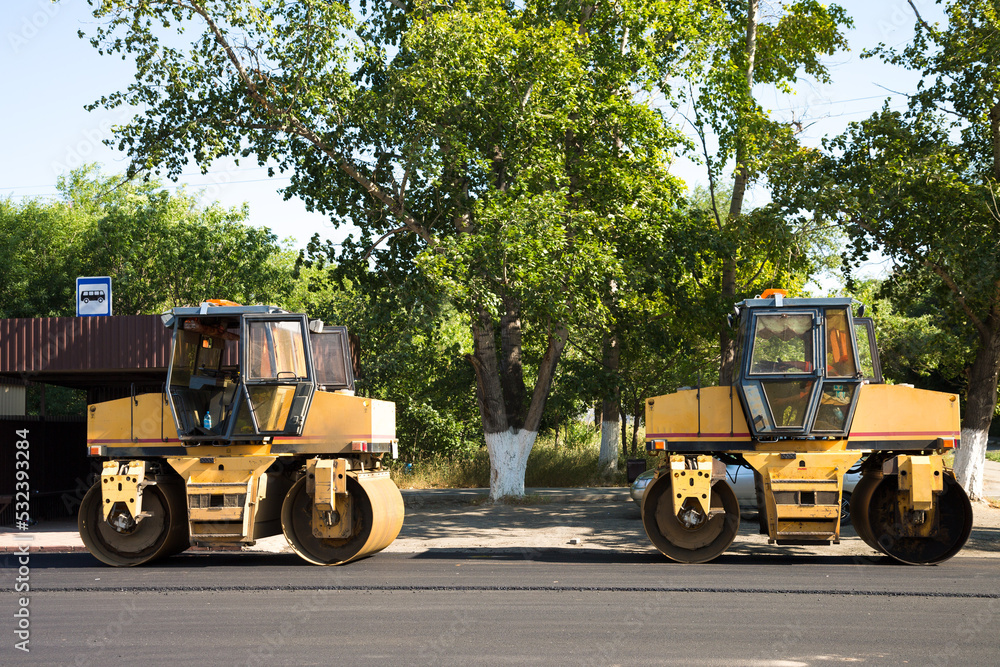 An asphalt paver is a skating rink for repairing roads on the streets of the city, standing idle during the lunch break. An asphalt paver is a skating rink for repairing roads on the streets of the city, standing idle during the lunch break.
