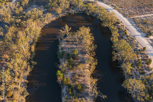 Aerial view of a hairpin bend in a murky river lined with gumtrees photo