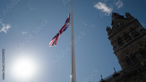 Union flag flying at half mast for the death of Queen Elizabeth II outside Chester city hall. Slow motion cinematic shot. photo