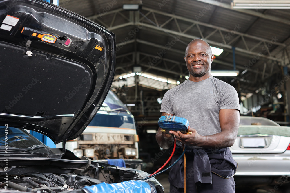 Mechanic in half uniform checking car air conditioning system refrigerant recharge, leak detection, fill refrigerant service..Concept of car center repair service. Mechanic in half uniform checking car air conditioning system refrigerant recharge, leak detection, fill refrigerant service..Concept of car center repair service.