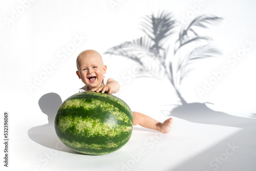 Funny toddler boy playing with watermelon, healthy fruit snack on white background, hot summer day. Organic vegan healthy diet, feeding, solid food concept. Cute baby, child, kid emotins. Copy space