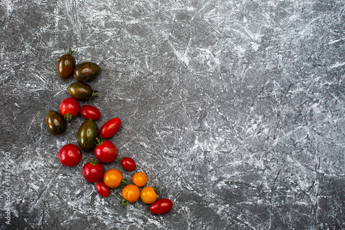 Tomatoes on a black and white background yellow red brown burgundy tomatoes healthy food fresh vegetables bright food vegan background for a menu site in a restaurant top view flat lay