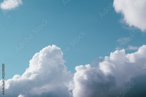 White, fluffy clouds in blue sky. Background from cumulus clouds. Scenery above the clouds