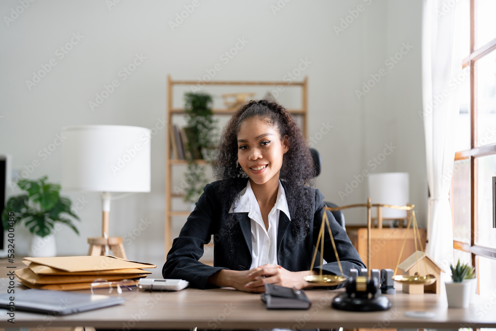 Portrait smiling female lawyer sitting at workplace in office - obrazy, fototapety, plakaty 