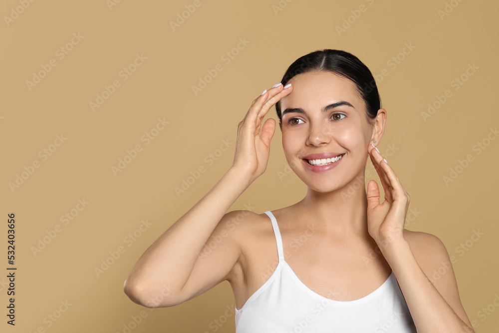 Beautiful young woman with perfect skin on beige background, space for text Beautiful young woman with perfect skin on beige background, space for text