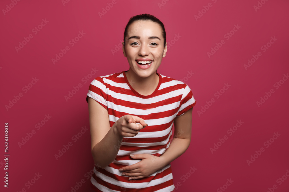 Beautiful young woman laughing on maroon background. Funny joke Beautiful young woman laughing on maroon background. Funny joke