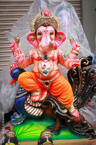 A Vibrant colored idol of Lord Ganesh sitting majestically during the Ganesh Chaturthi festival in India. 
