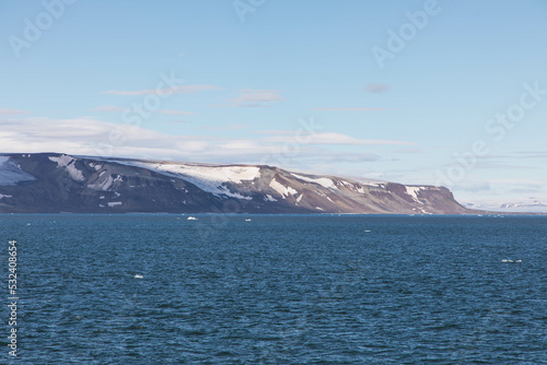Spectacular panorama view of Wilhelmoya island with mountain range and blue sky. Torellneset, Nordaustlandet  
Spitsbergen, Norway. Tourism and vacations concept. photo