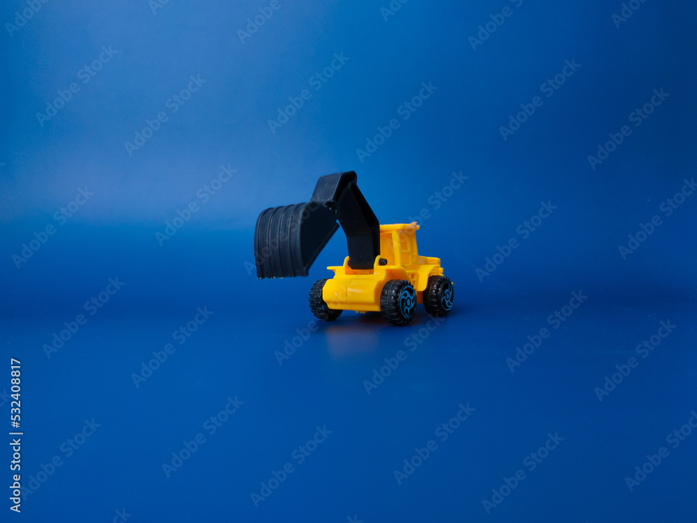 Excavator model isolated on blue background Excavator model isolated on blue background